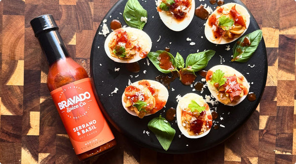 deviled eggs on cutting board with serrano and basil hot sauce