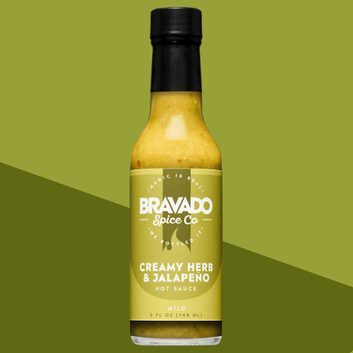 Bottle of Bravado Spice Co. Creamy Herb & Jalapeno hot sauce on a green background